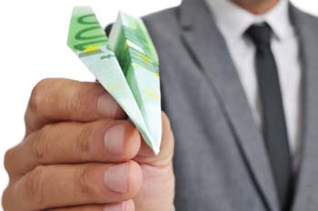 a businessman with a paper plane made ??with a 100 euro banknote in his hand